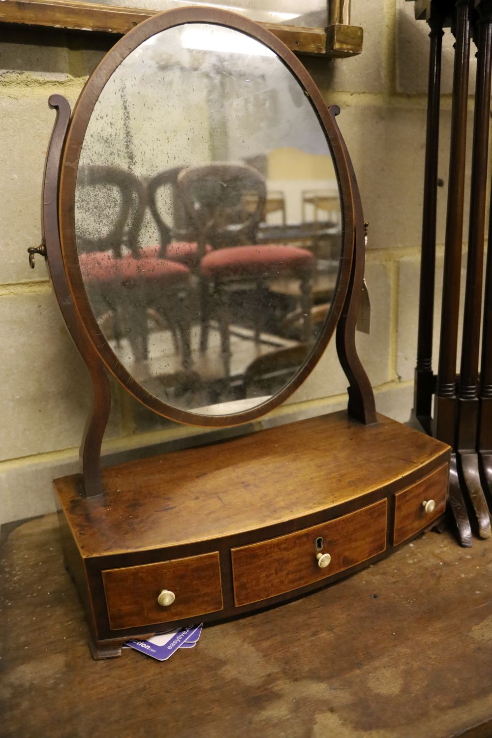 A nest of three mahogany tea tables, width 48cm depth 33cm height 67cm, and an oval swing frame toilet mirror with bow-fronted box base